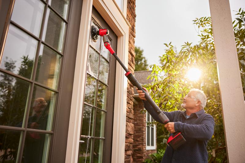 Side view of male cleaning windows with V20 Scrubber