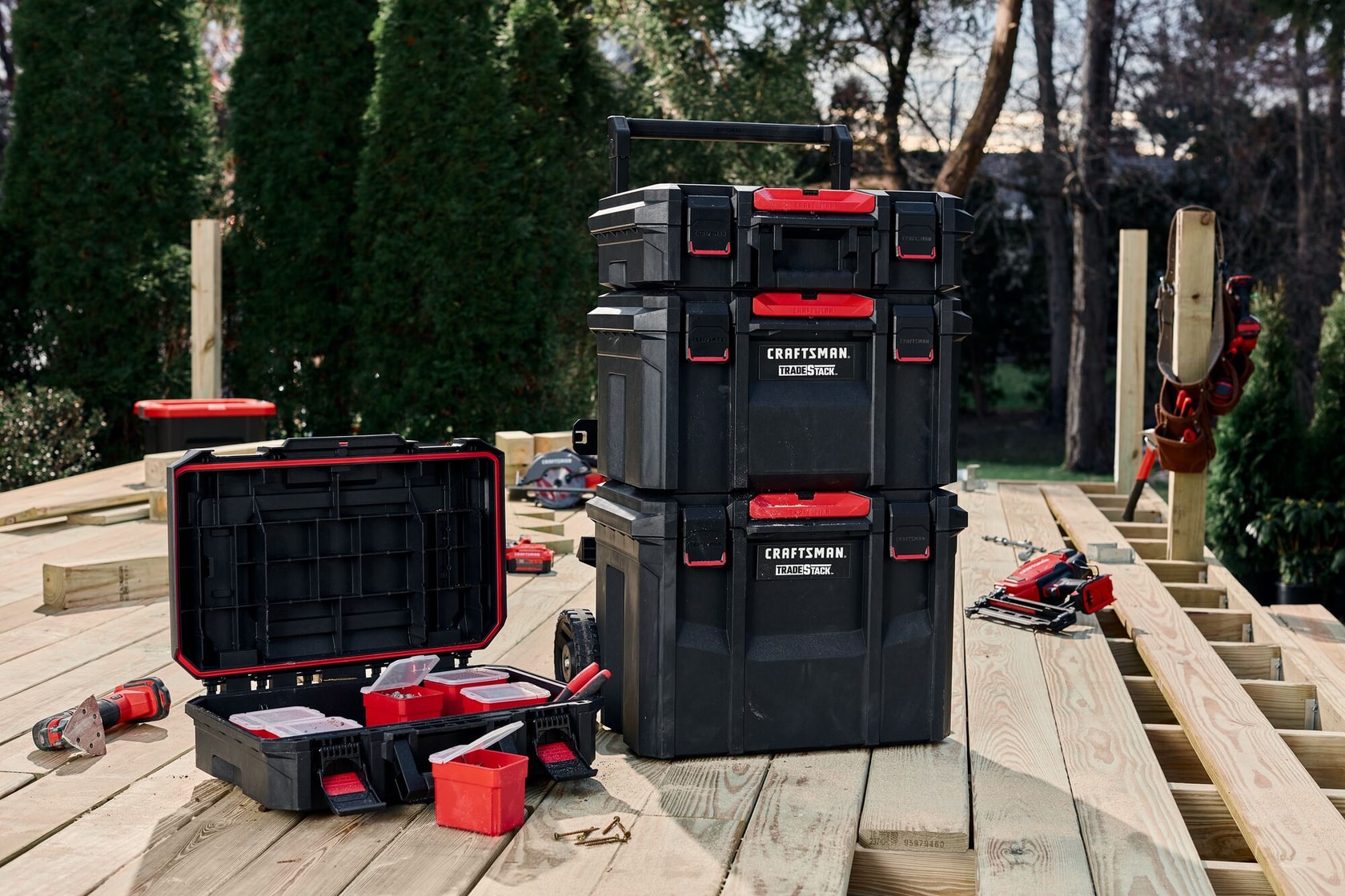 TradeStack Rolling Tower along with other tools and a storage box placed on wooden deck outdoors.